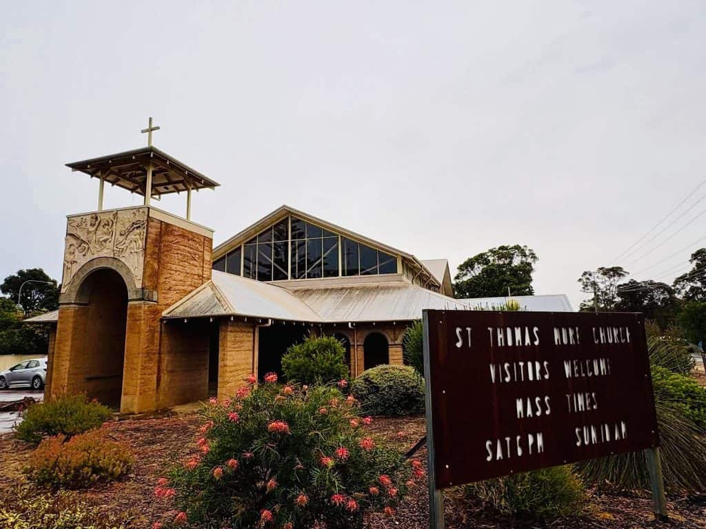 Exterior view of St Thomas More Church in Bunbury with signage and garden.