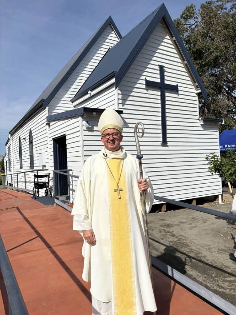 Clergy member in front of Bunbury Catholic Diocese church.