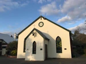 Bunbury Catholic Diocese church with stained glass windows and cross on roof.