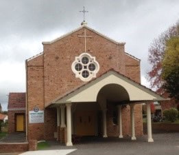 Bunbury Catholic Church building with brick facade and circular window.
