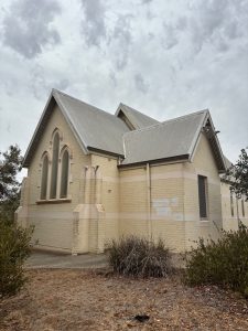 Historic church building of Bunbury Catholic Diocese under cloudy sky.