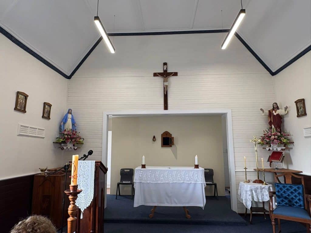 Interior of a Catholic chapel with altar, crucifix, and religious statues.